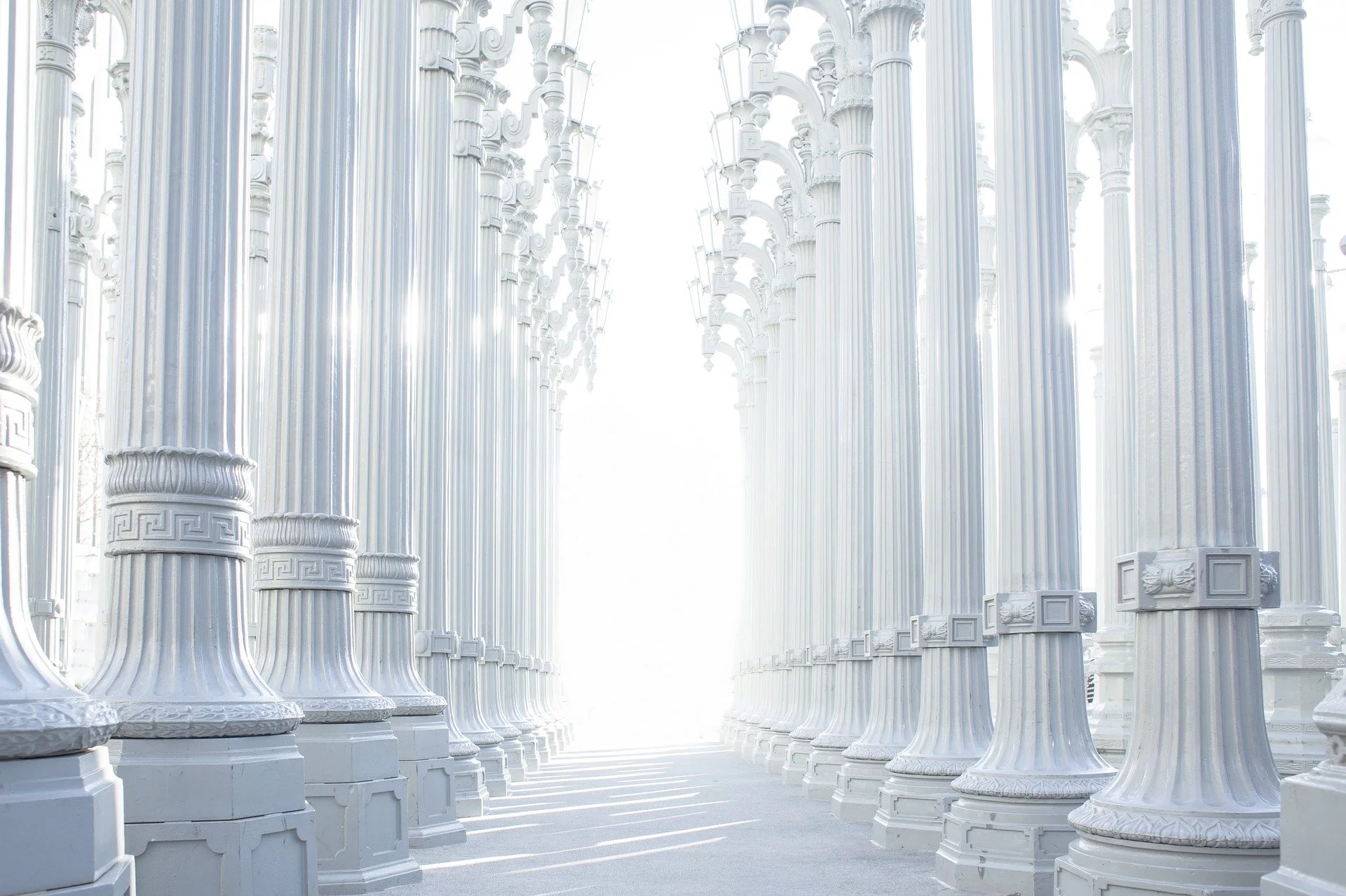 Une allée blanche avec des colonnes blanche.