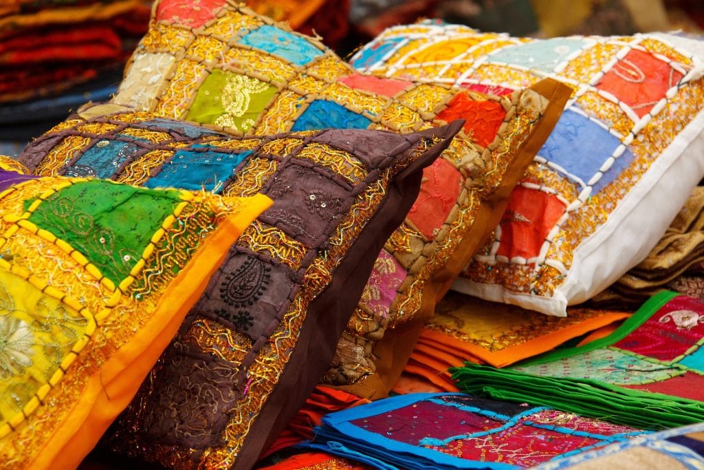 Plusieurs coussins colorés et texturés alignés les uns derrières les autres.